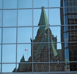 Government building reflected in glass building windows